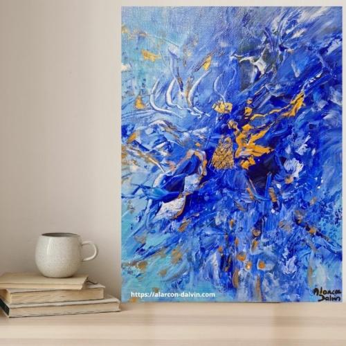 Tableau abstrait bleu et or à côté d’une tasse à café et de livres – ambiance cosy et élégante