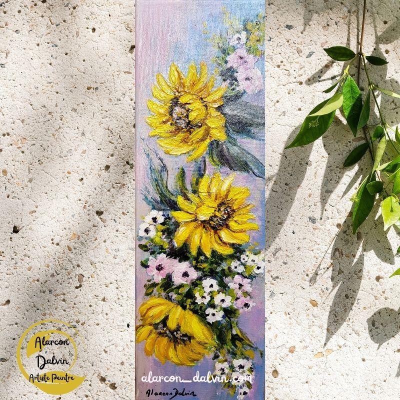 Gros plan sur les tournesols jaunes peints à l’acrylique, révélant les détails de texture et de couleurs sur le fond bleu turquoise.